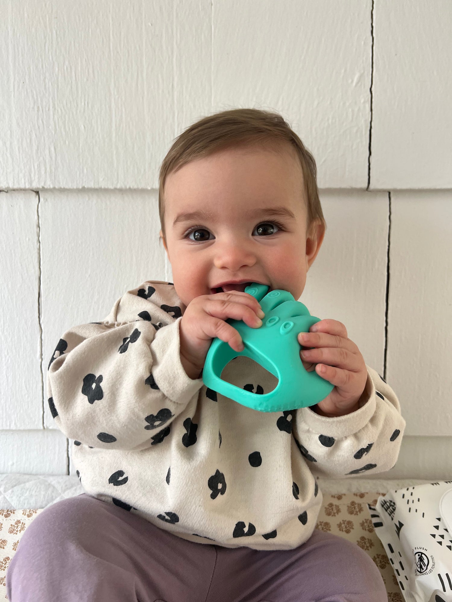 hand-shaped silicone baby teether flatlay photo

baby holding hand-shaped teether

silicone teething toy for sore gums

soft silicone teether safe baby toy